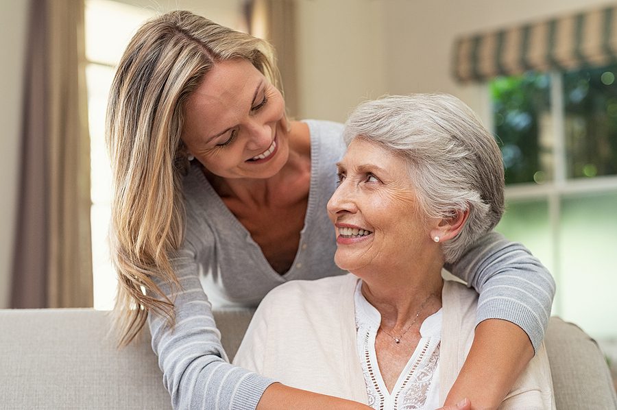 Adult daughter and older adult mother hug after discussing how to maintain healthy family relationships
