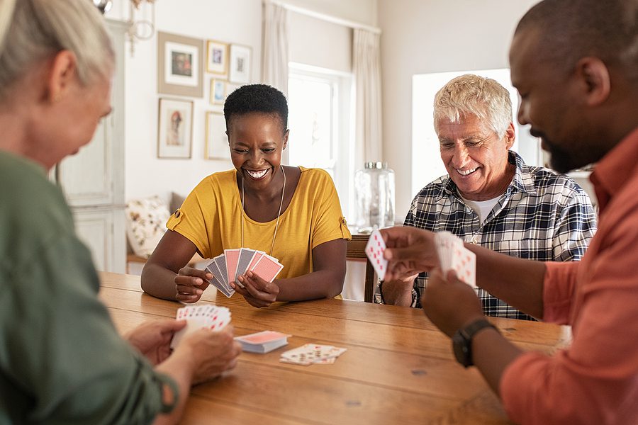 Two senior couples play a game of cards